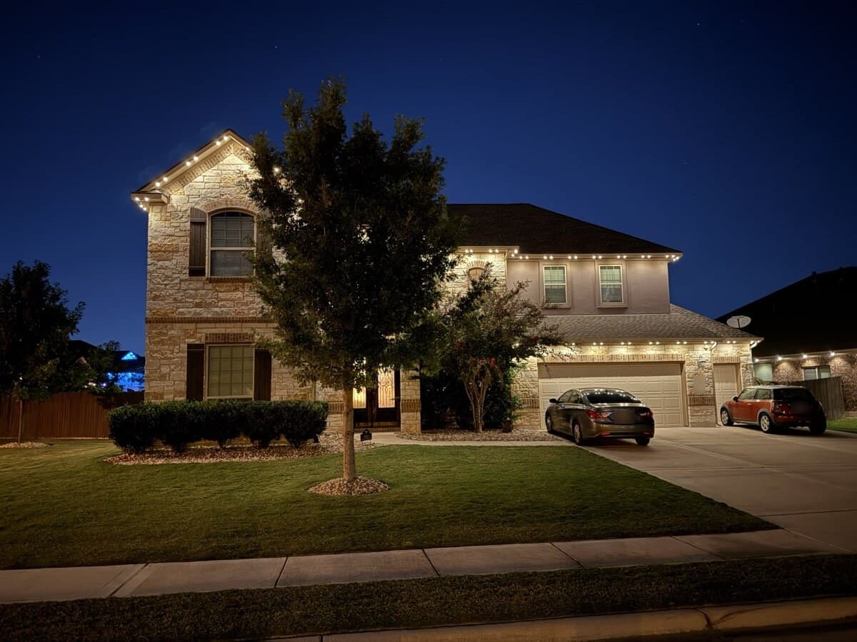 TruLight permanent roofline lighting in warm white on a Texas home at night