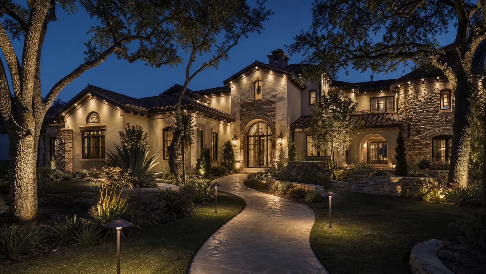 Warm-white landscape lighting on a fictional luxury Spanish-modern estate